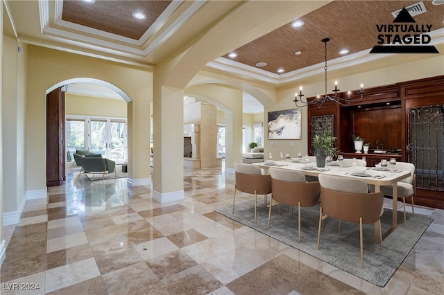 dining area with a towering ceiling, a tray ceiling, crown molding, and a notable chandelier