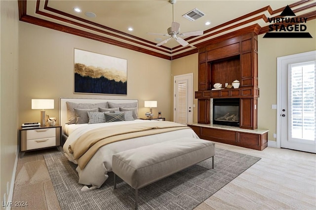 carpeted bedroom with access to exterior, a large fireplace, ceiling fan, and crown molding