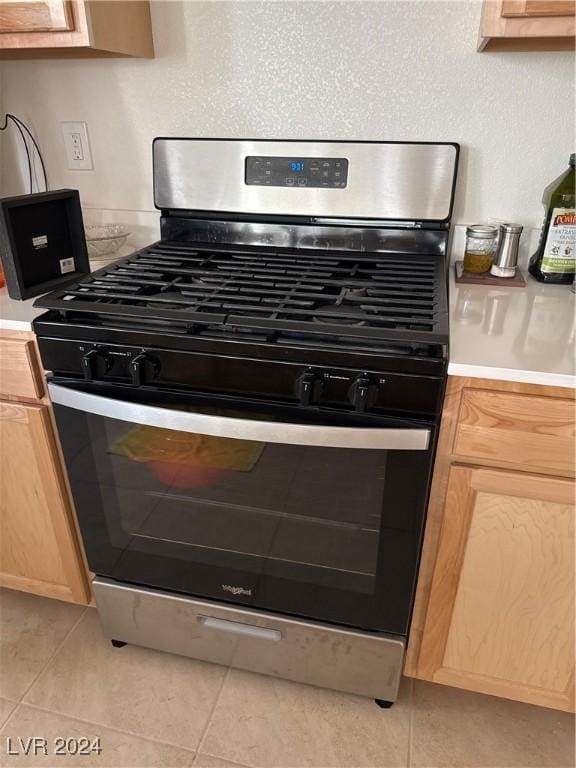 details featuring light brown cabinetry and stainless steel gas range oven