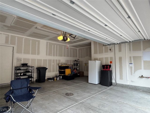 garage with a garage door opener and white refrigerator