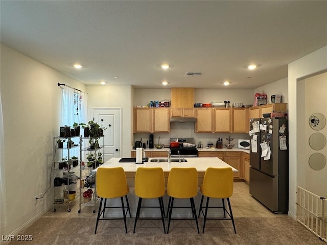 kitchen with sink, stainless steel electric range oven, light carpet, a center island with sink, and fridge