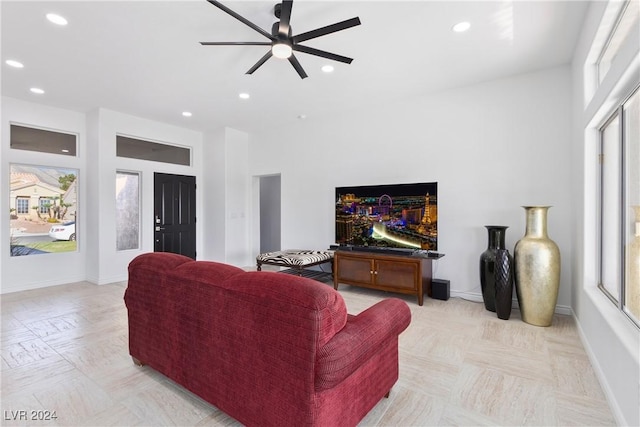 living room featuring ceiling fan, plenty of natural light, and light parquet flooring