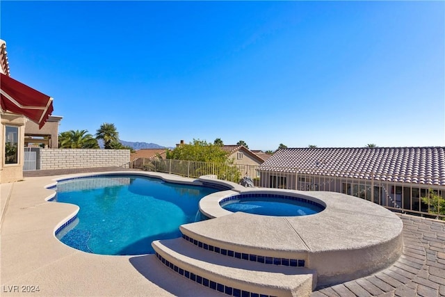 view of pool with a patio area and an in ground hot tub