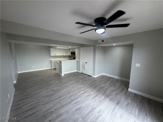 unfurnished living room with hardwood / wood-style floors and ceiling fan