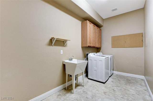 laundry area with separate washer and dryer and cabinets