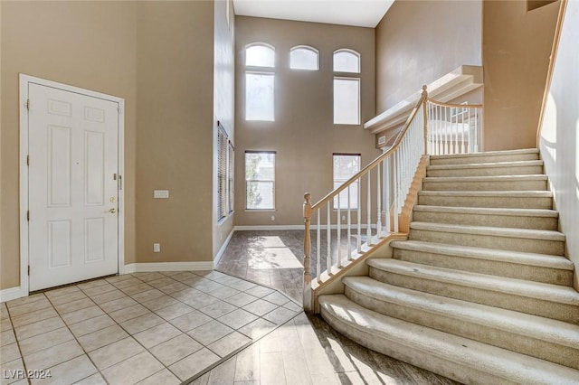 tiled foyer entrance featuring plenty of natural light and a towering ceiling