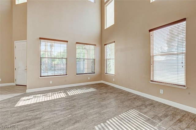 empty room with a high ceiling and light hardwood / wood-style floors