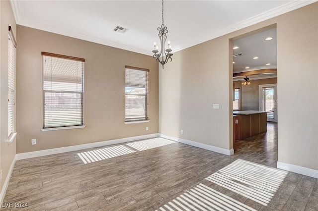 spare room featuring dark wood-type flooring, ceiling fan with notable chandelier, and ornamental molding