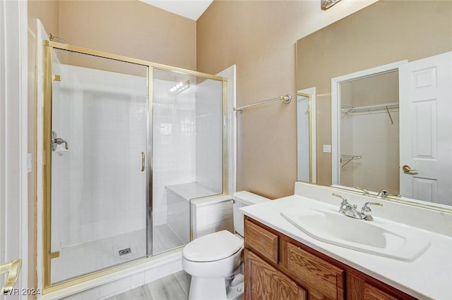 bathroom with vanity, hardwood / wood-style flooring, toilet, and an enclosed shower