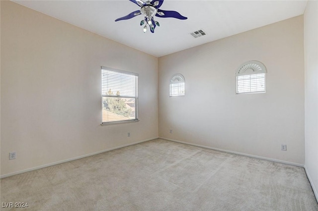 carpeted spare room featuring ceiling fan