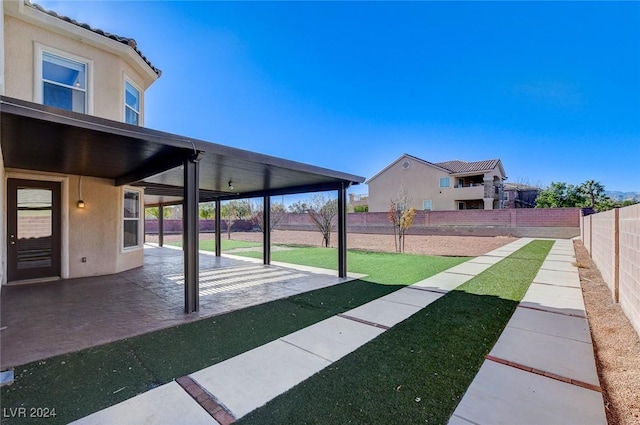 view of yard featuring ceiling fan and a patio area