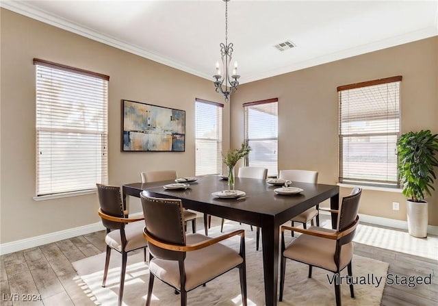 dining area featuring a chandelier, light hardwood / wood-style flooring, and ornamental molding