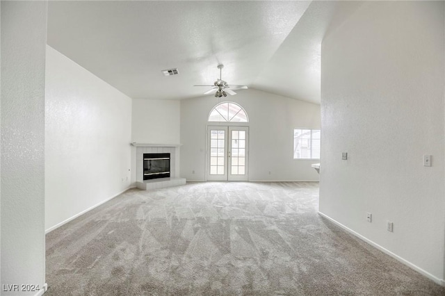 unfurnished living room with ceiling fan, a fireplace, light colored carpet, and vaulted ceiling