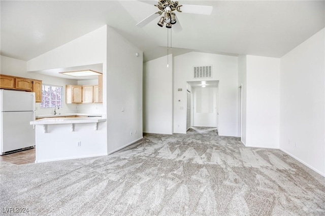 unfurnished living room featuring ceiling fan, light carpet, and vaulted ceiling