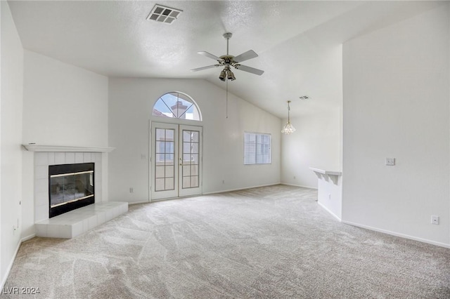 unfurnished living room featuring ceiling fan, a fireplace, light colored carpet, and vaulted ceiling