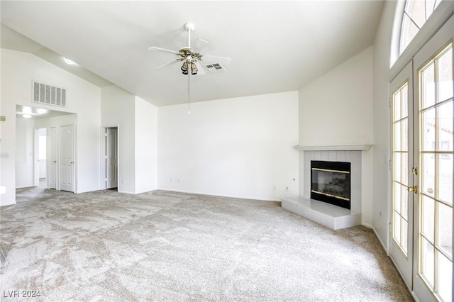 unfurnished living room with light carpet, high vaulted ceiling, a fireplace, and ceiling fan