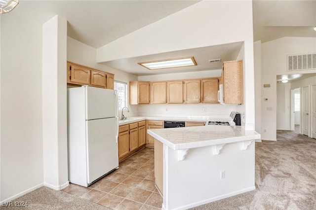 kitchen with light carpet, kitchen peninsula, white appliances, sink, and lofted ceiling