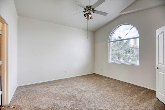 carpeted spare room with ceiling fan and vaulted ceiling