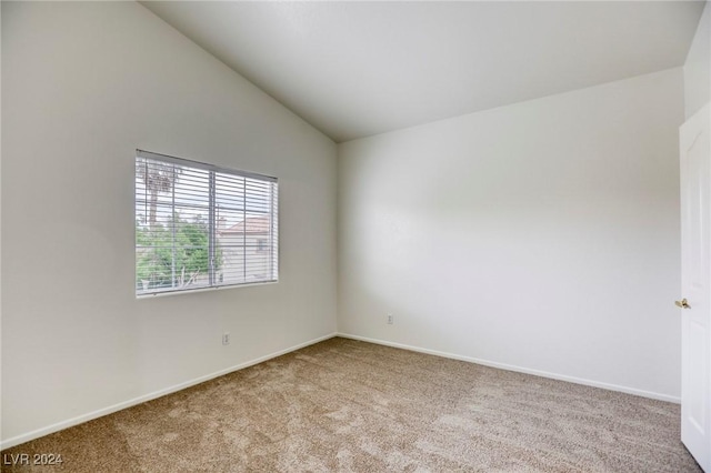 spare room with light carpet and lofted ceiling