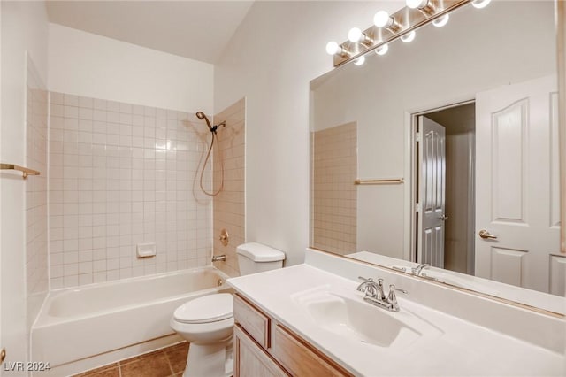 full bathroom featuring tile patterned floors, tiled shower / bath combo, toilet, and vanity