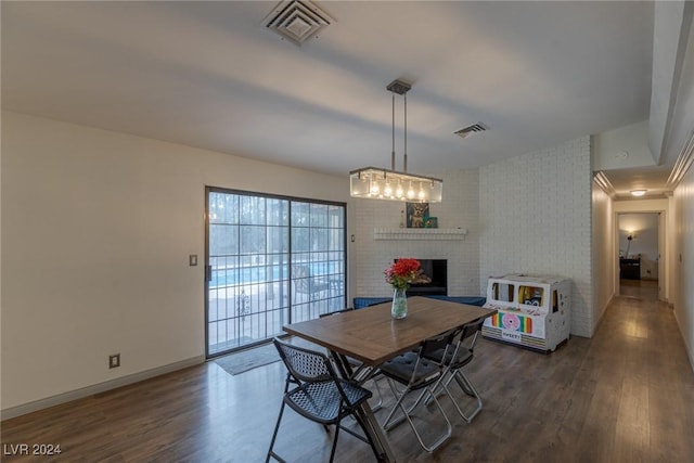 dining room featuring dark hardwood / wood-style floors and a brick fireplace