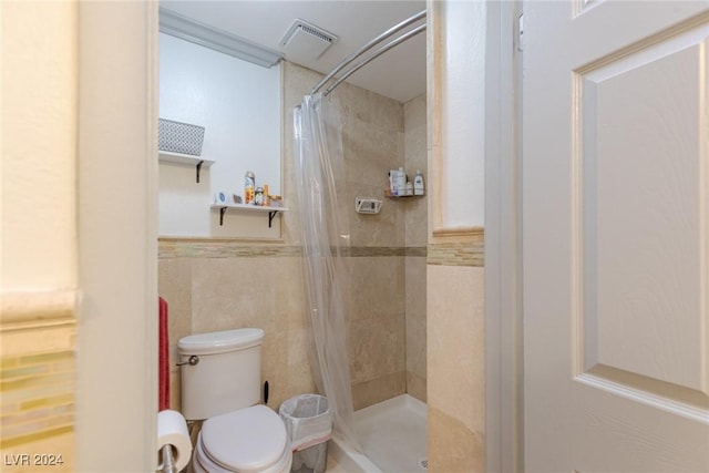 bathroom featuring a shower with curtain, toilet, and tile walls