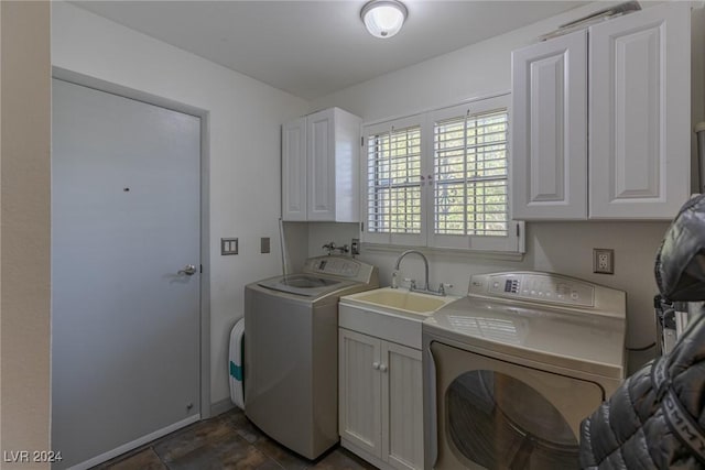 washroom featuring cabinets, washing machine and dryer, and sink