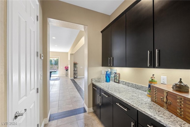 kitchen featuring light tile patterned flooring and light stone countertops