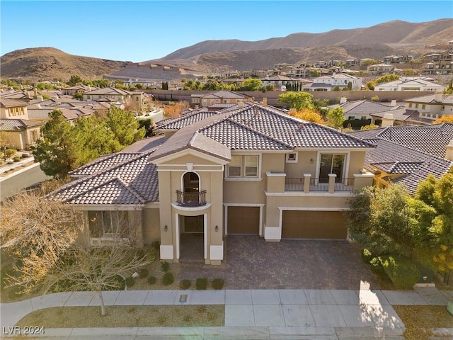 view of front facade featuring a mountain view, a balcony, and a garage