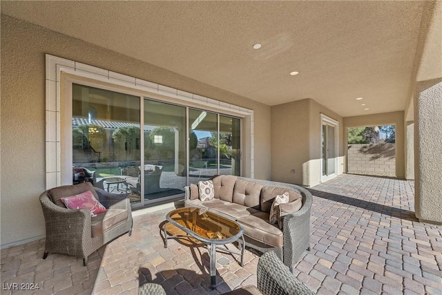 view of patio with an outdoor living space with a fire pit