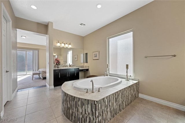 bathroom featuring tile patterned floors, vanity, and tiled tub