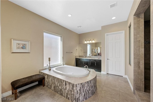 bathroom with vanity, tile patterned flooring, and a relaxing tiled tub