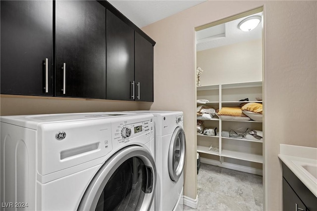 washroom featuring washing machine and clothes dryer and cabinets