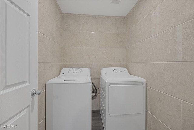 washroom featuring separate washer and dryer and tile walls