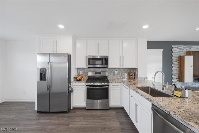 kitchen featuring light stone countertops, white cabinetry, sink, dark wood-type flooring, and appliances with stainless steel finishes