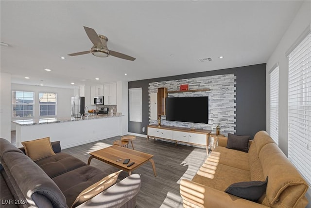 living room with ceiling fan and dark wood-type flooring