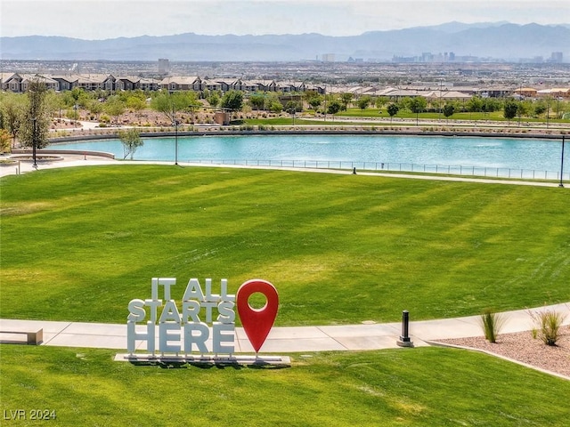 view of community with a yard and a water and mountain view