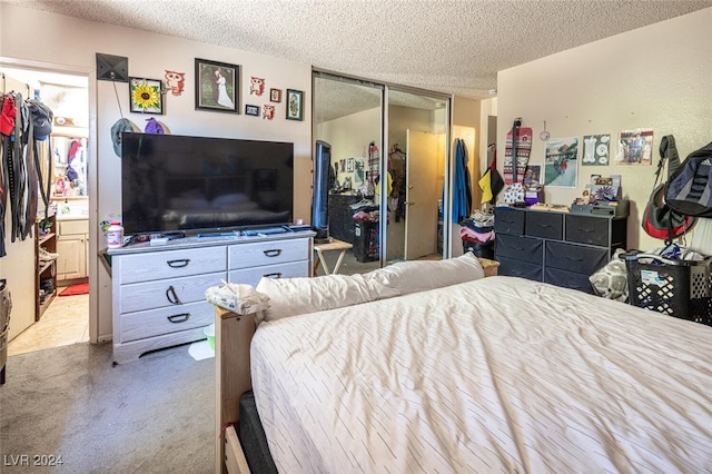 carpeted bedroom with a textured ceiling and a closet