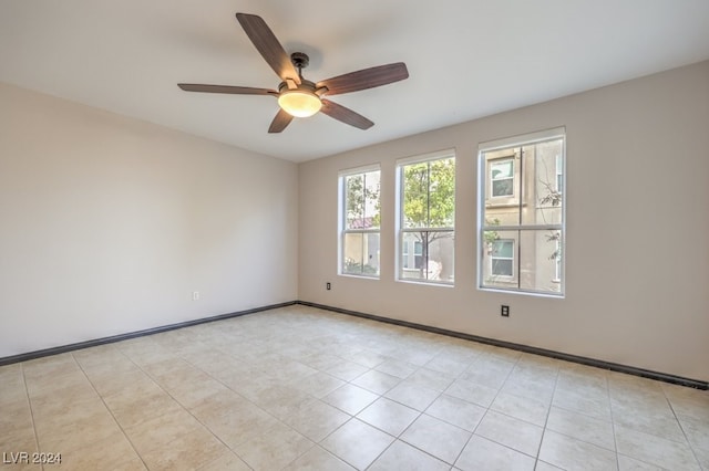 tiled spare room featuring ceiling fan