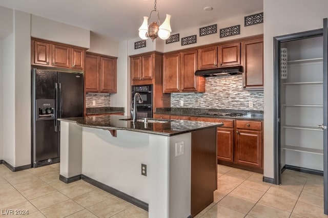 kitchen with sink, an inviting chandelier, a center island with sink, light tile patterned flooring, and black appliances