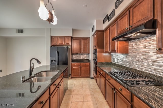 kitchen with pendant lighting, sink, dark stone countertops, appliances with stainless steel finishes, and tasteful backsplash