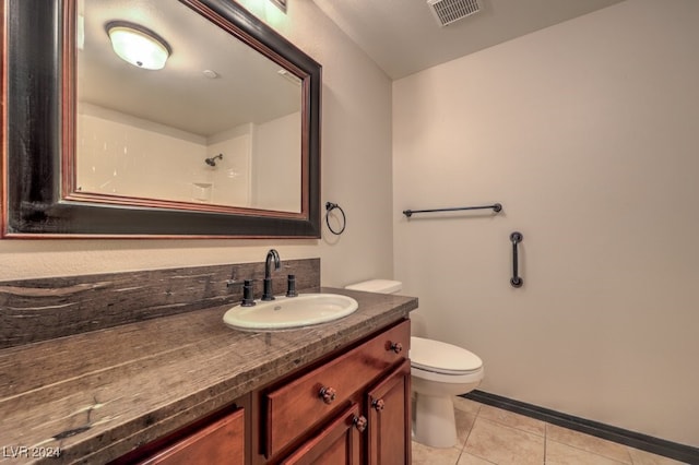 bathroom with tile patterned flooring, vanity, and toilet