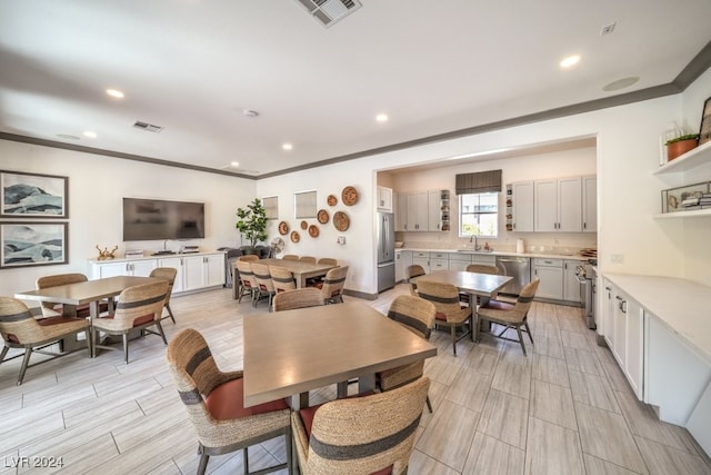 dining area featuring ornamental molding and sink