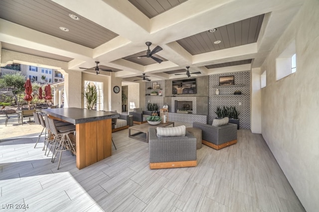 living room with beamed ceiling, coffered ceiling, and a tiled fireplace