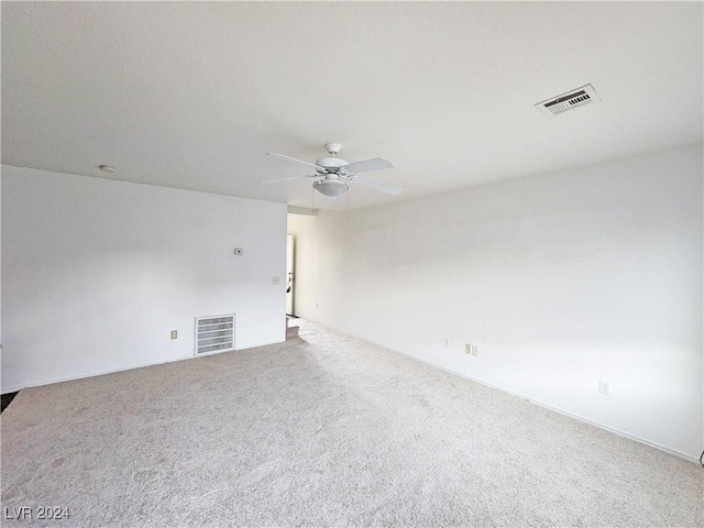 carpeted spare room featuring ceiling fan