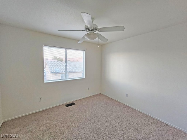 carpeted spare room featuring ceiling fan