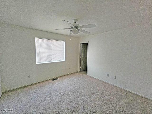 spare room with light colored carpet and a textured ceiling