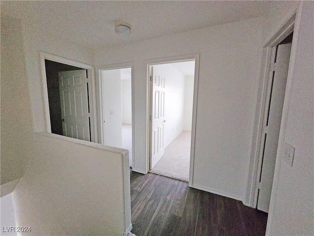 corridor with dark hardwood / wood-style flooring and a textured ceiling