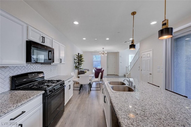 kitchen featuring sink, white cabinetry, black appliances, pendant lighting, and backsplash