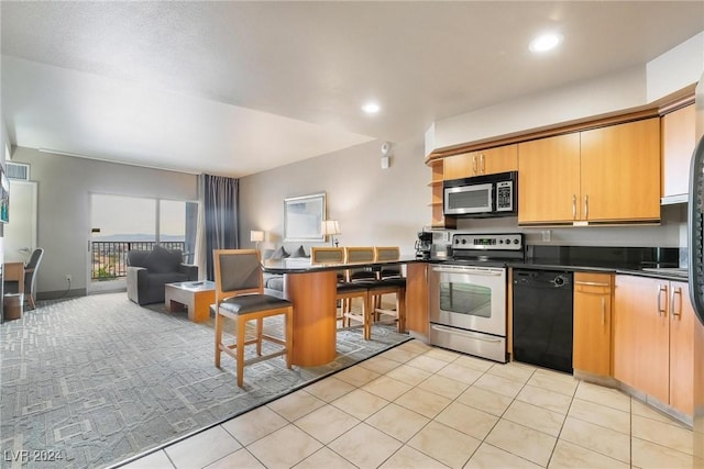 kitchen featuring a breakfast bar, stainless steel appliances, and light tile patterned flooring